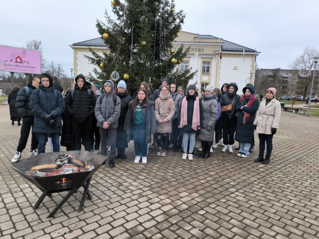 Izglītojamie un skolotāji pie ugunskura